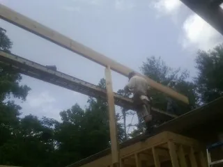 Carpenter setting a ridge beam over a new addition frame — Ice Dam Removal by Roofing Brothers in Blowing Rock