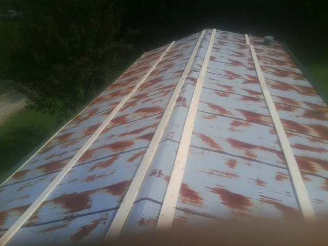Rusted metal roof panels with new wood purlins before replacement — Storm Damage Roof Repair in Blowing Rock by Roofing Brothers