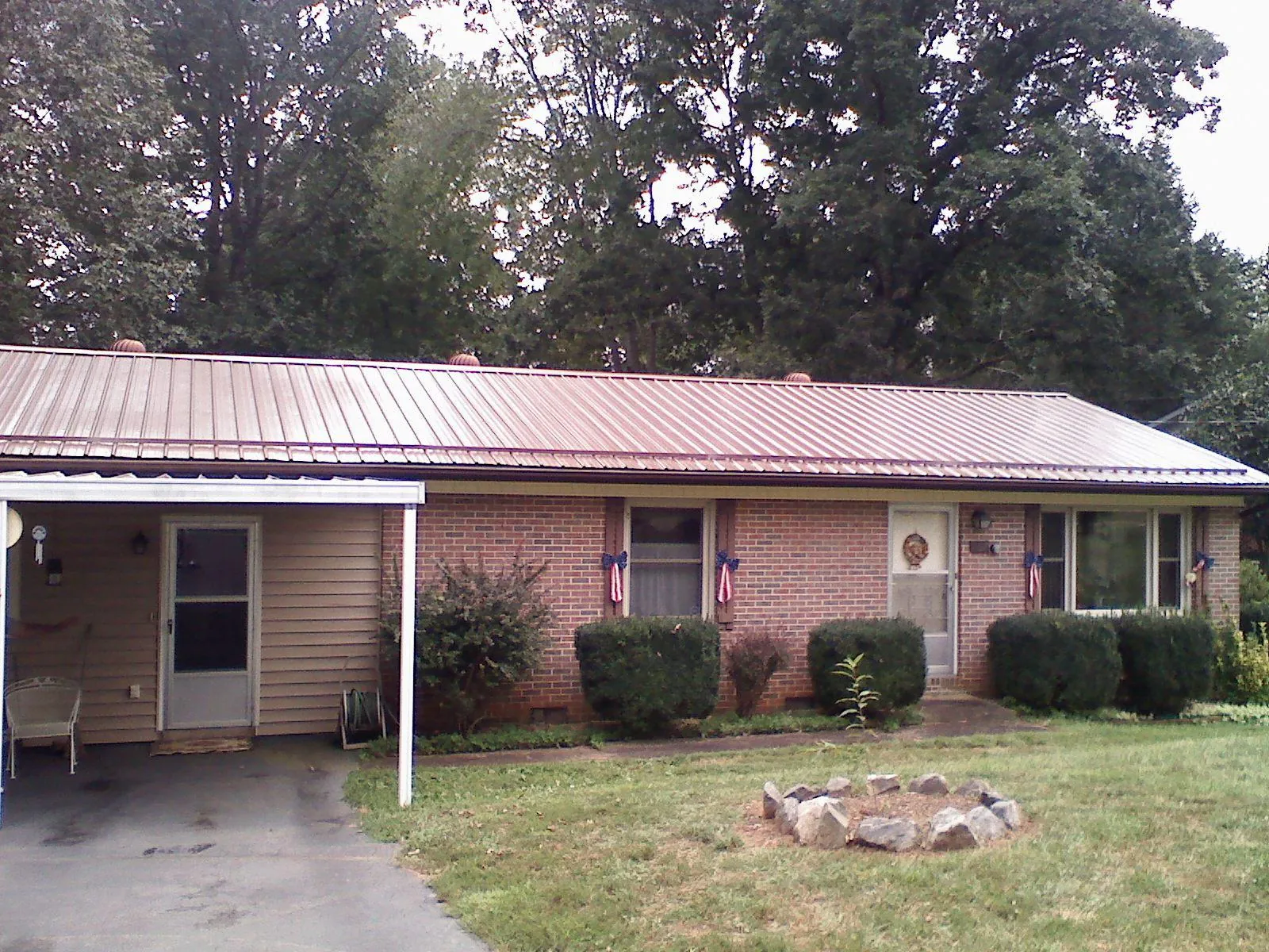 Bronze metal roof and carport on a brick ranch home — Roof Repair work by our crew in Blowing Rock