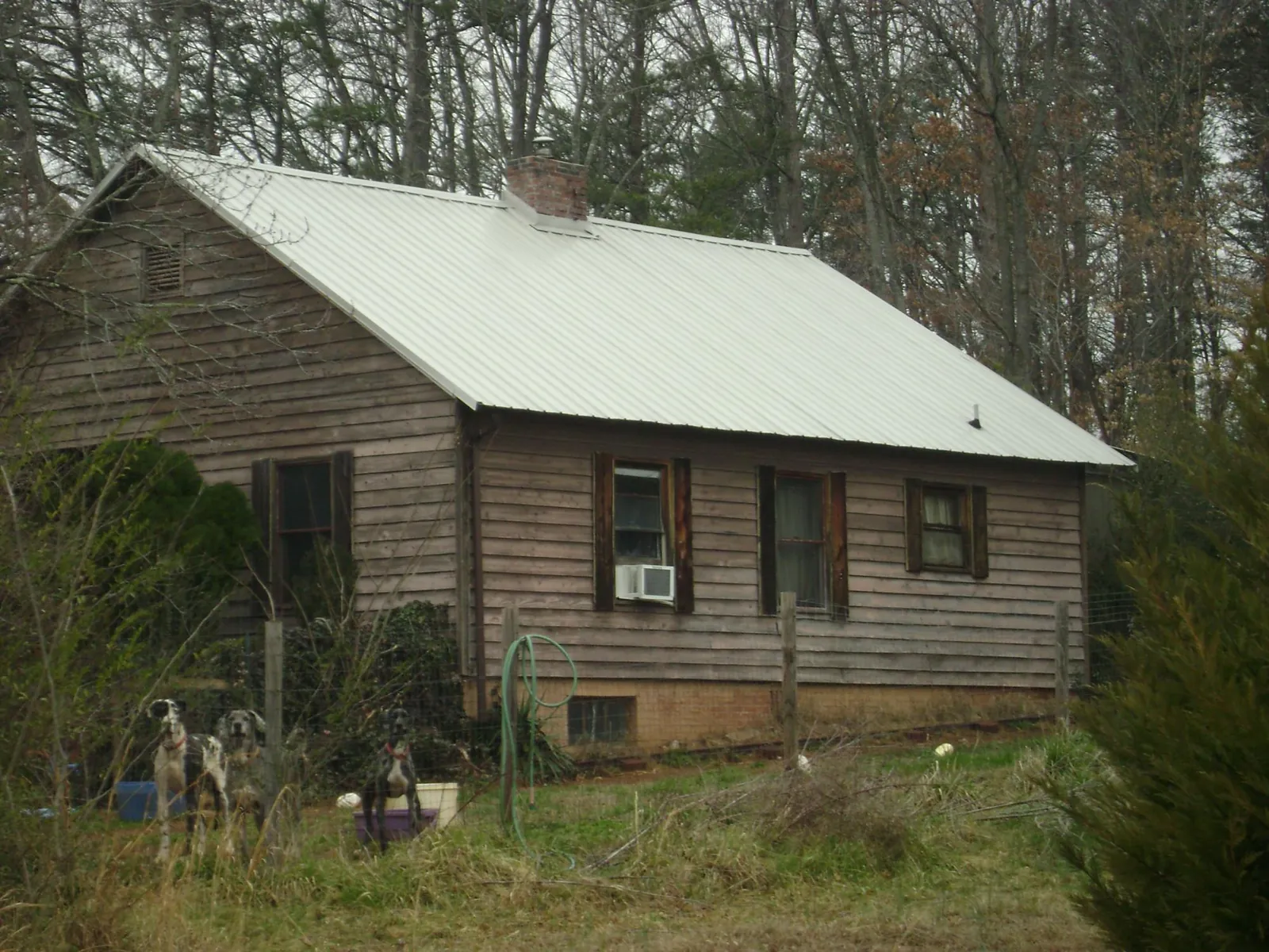 White metal roof on an old wood sided farmhouse, from a Metal Roof Installation job in Blowing Rock